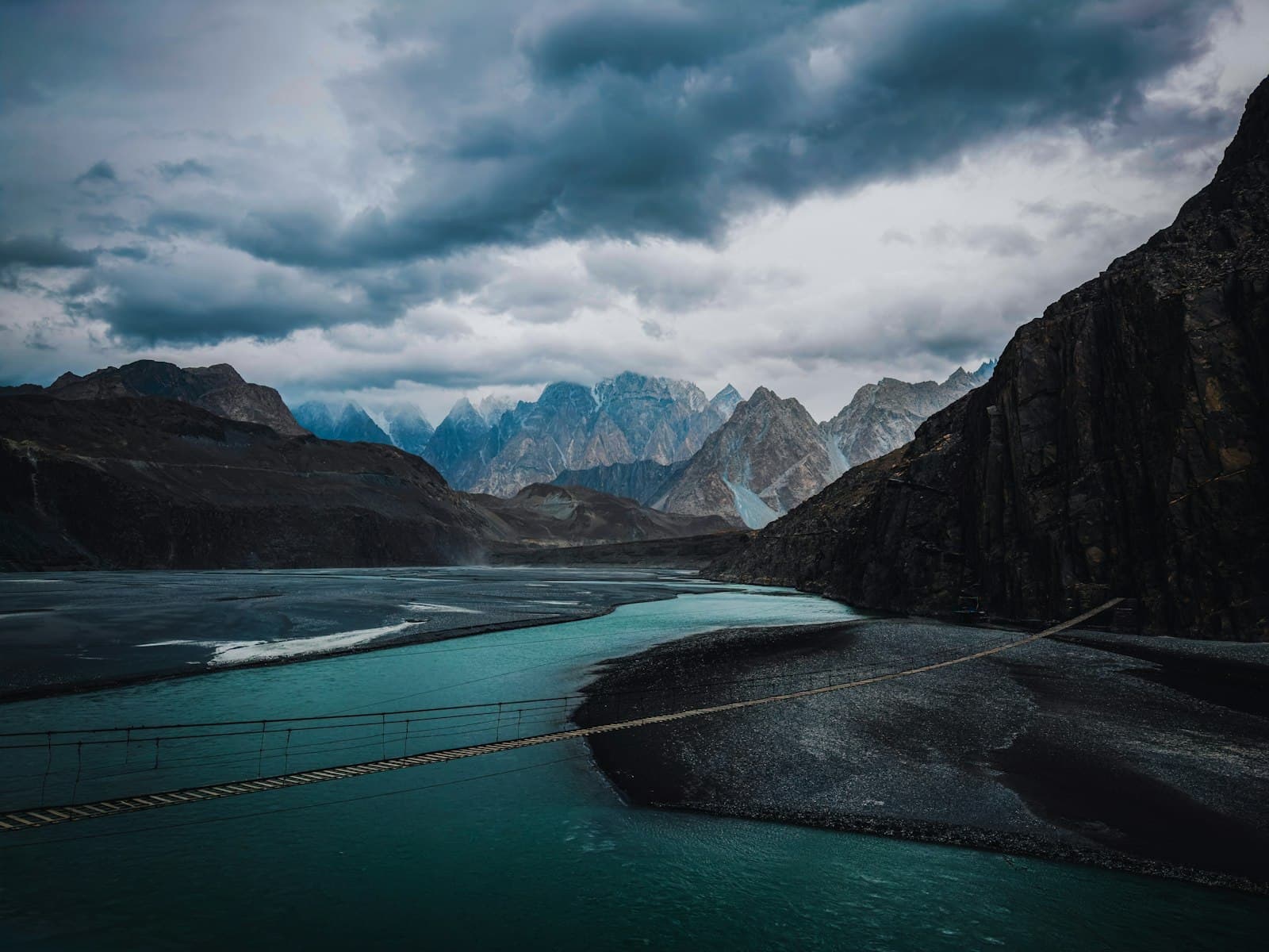 A river crossing beneath dramatic peaks — entering the promised land