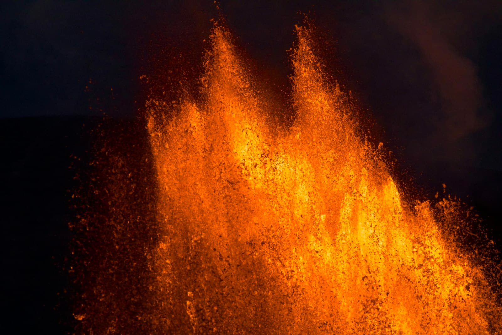 A wall of molten fire against black — the refiner's fire